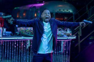 Martin Lawrence wielding two handguns with a crazed look on his face.